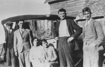 A vintage photo of a group of people posing for the camera

Description automatically generated