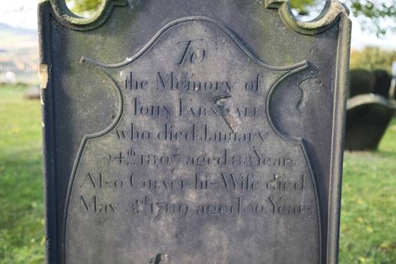Close-up of a tombstone with engraved text

Description automatically generated