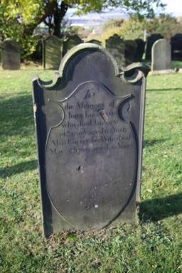 A tombstone in a cemetery

Description automatically generated