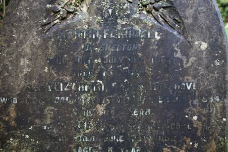 Close-up of a tombstone with writing on it

Description automatically generated