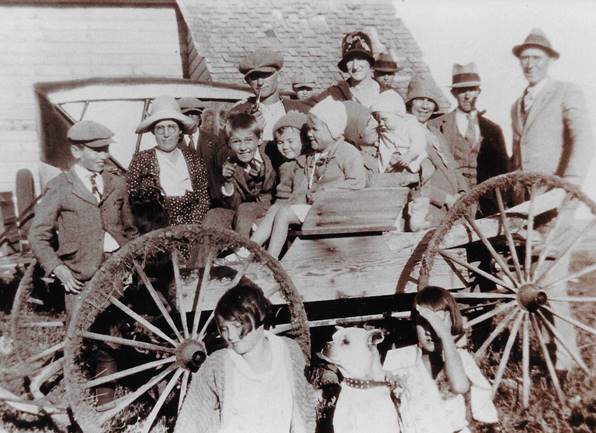 A group of people standing in front of a wagon

Description automatically generated