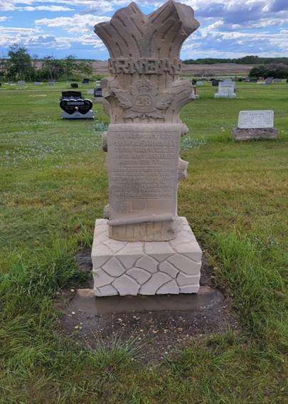 A stone monument in a cemetery

Description automatically generated