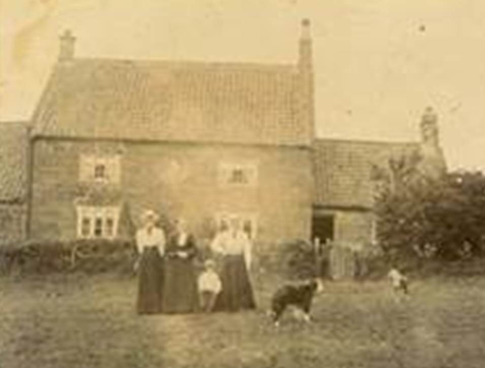 A group of people standing in front of a house

Description automatically generated