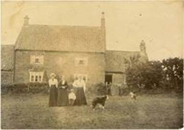 A group of people standing in front of a house

Description automatically generated