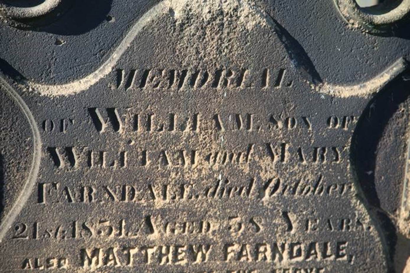 A close-up of a grave stone

Description automatically generated