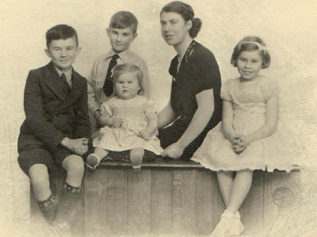 A vintage photo of a group of people posing for the camera

Description automatically generated