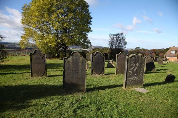 A group of headstones in a cemetery

Description automatically generated