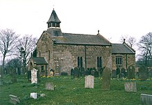 A stone church with a cemetery

Description automatically generated