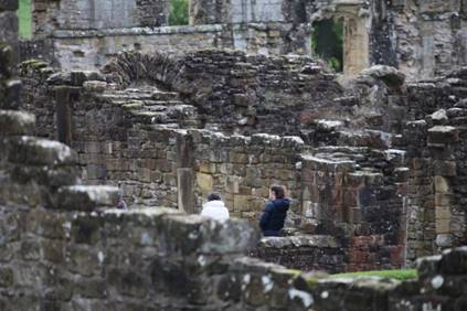 A group of people standing in a ruined building

Description automatically generated