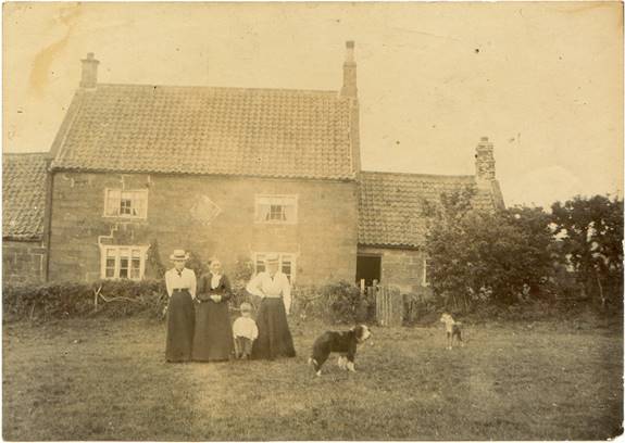 A group of men standing in front of a house

Description automatically generated