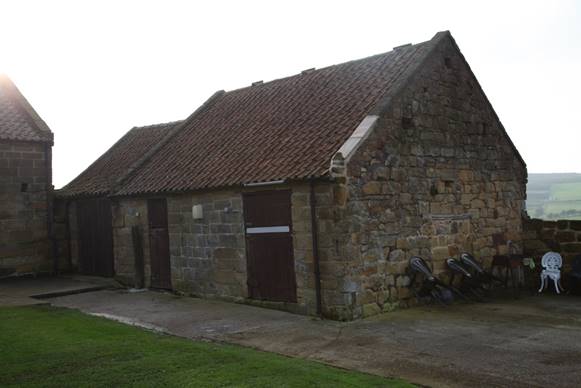 A stone building with a red roof

Description automatically generated