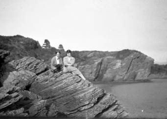 A couple of people sitting on a rock

Description automatically generated