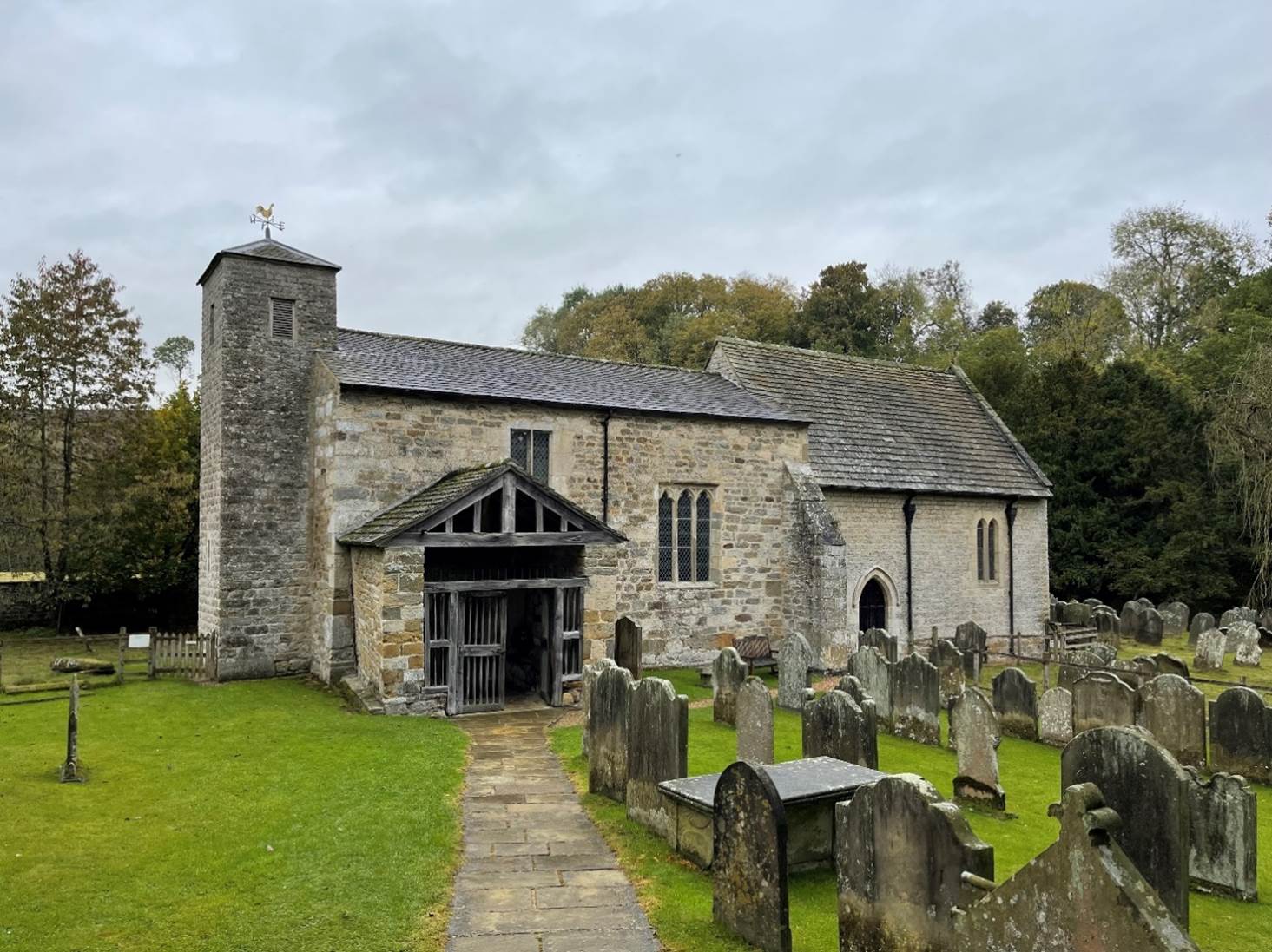 A stone church with a cemetery

Description automatically generated