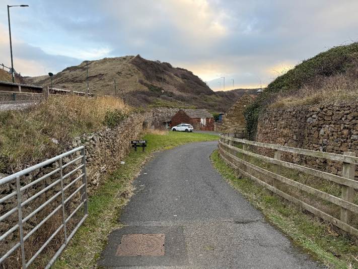 A road with a fence and grass

AI-generated content may be incorrect.