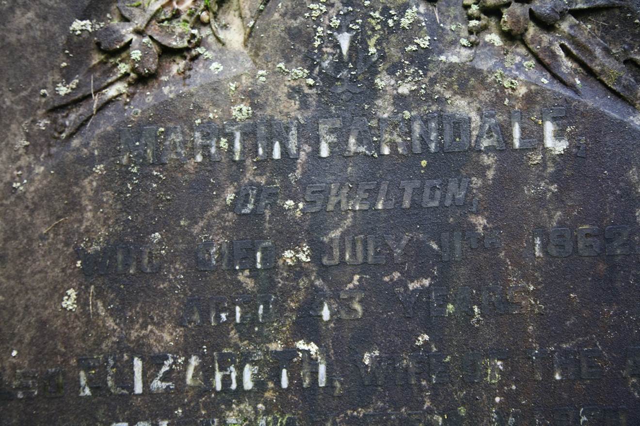 Close-up of a tombstone with engraved text

Description automatically generated