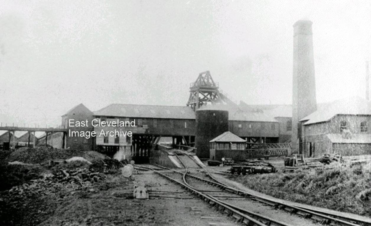 A black and white photo of a factory
Description automatically generated