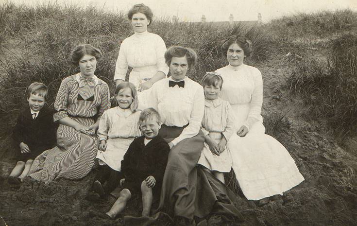 A vintage photo of a group of people posing for the camera

Description automatically generated