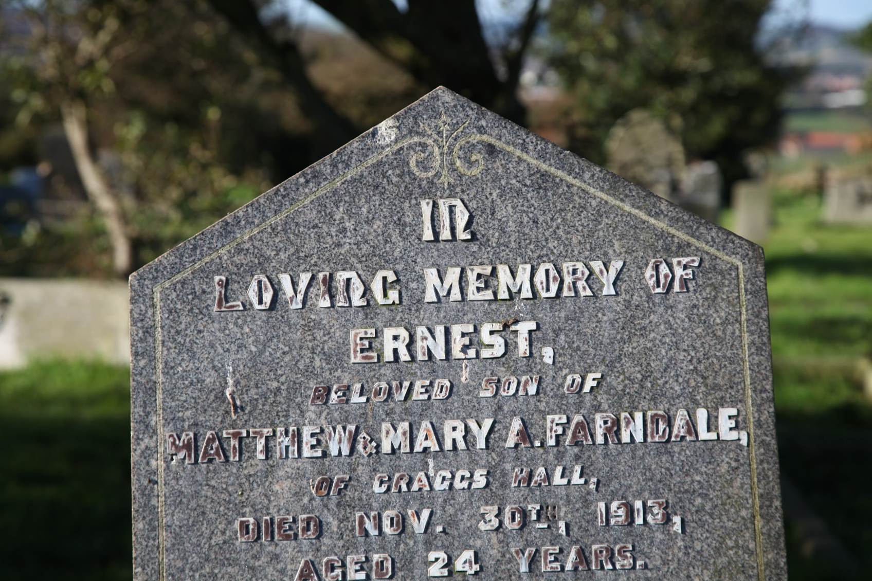 A close-up of a grave stone
Description automatically generated