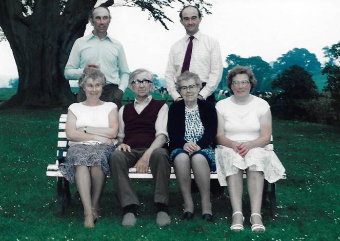 A group of people sitting on a bench

Description automatically generated