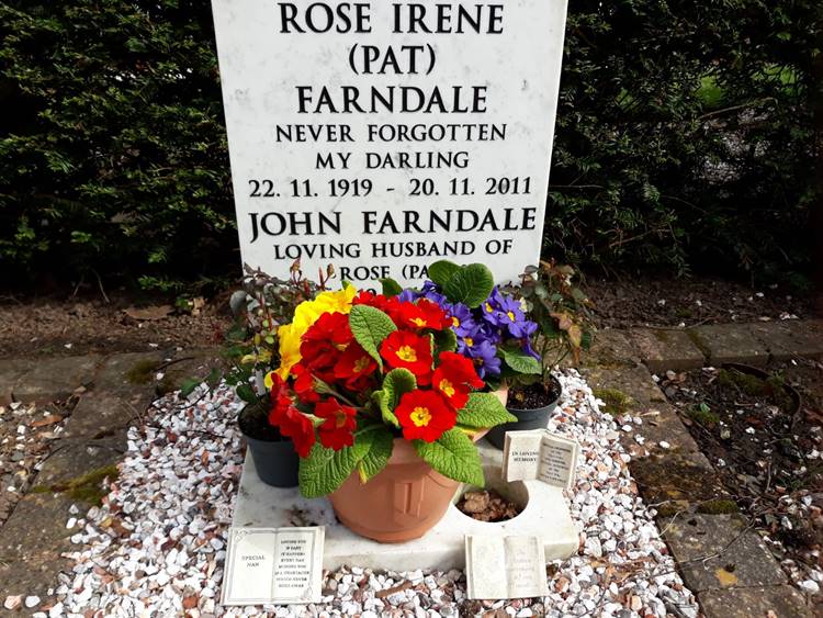 A grave stone with flowers in it

Description automatically generated