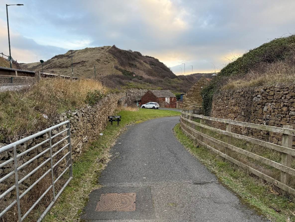 A road with a fence and grass

AI-generated content may be incorrect.