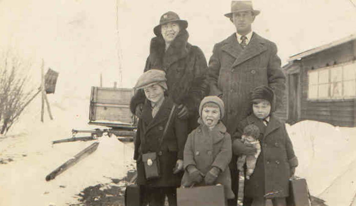 A family posing for a photo in the snow
Description automatically generated