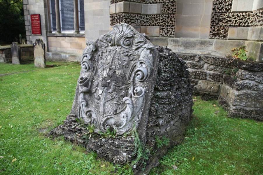 A stone grave stone in a yard

Description automatically generated with medium confidence