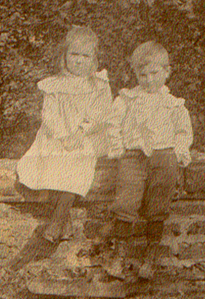 A couple of children sitting on a log
Description automatically generated