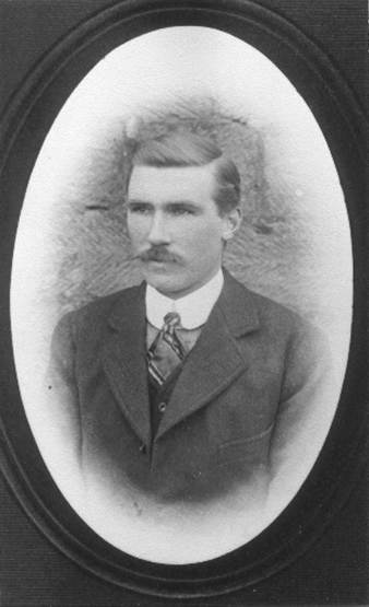 A person with a mustache wearing a suit
Description automatically generated