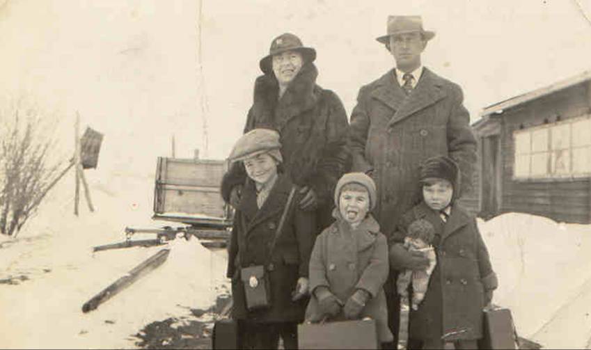 A family posing for a photo in the snow
Description automatically generated