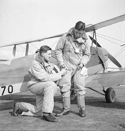 Instructor and pupil in front of a de Havilland Tiger Moth at No. 7 EFTS, Desford. Both wear 1930 Pattern flying suits.