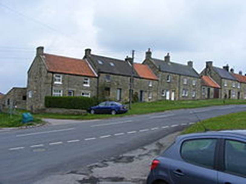 A row of houses on a street

Description automatically generated