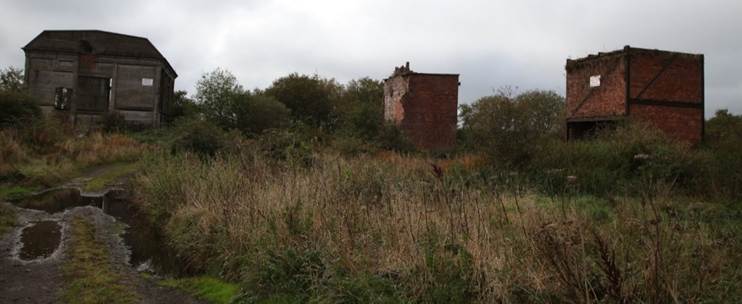 A dirt path leading to a ruined building
Description automatically generated with medium confidence