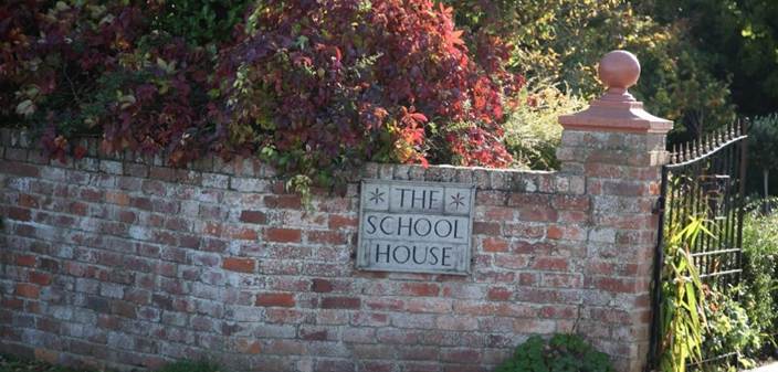 A brick wall with a sign on it
Description automatically generated