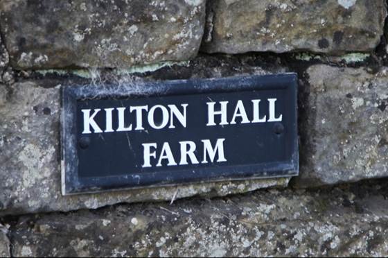 A sign on a stone wall

Description automatically generated