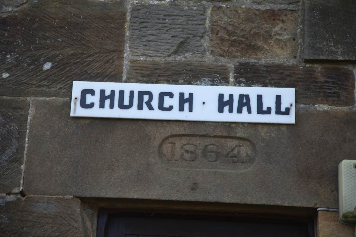 A sign on a stone wall
Description automatically generated