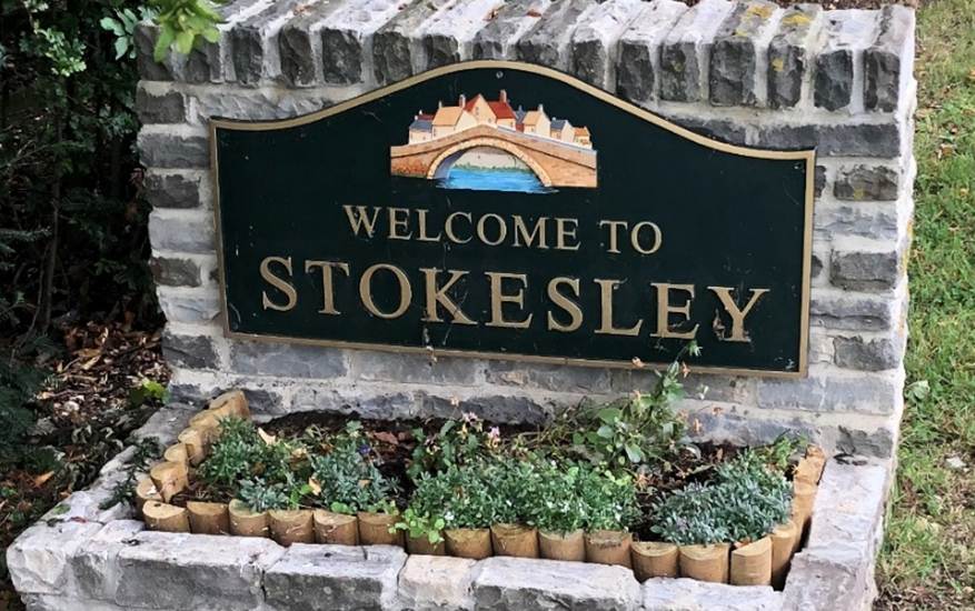 A sign in a garden
Description automatically generated